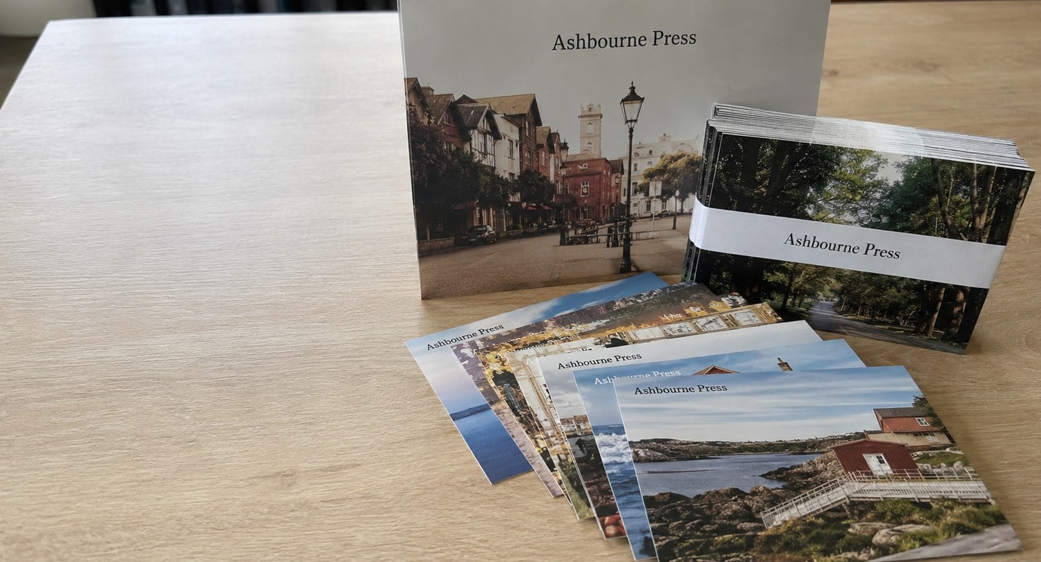 Custom printed postcards stacked on a desk beside a mail tray